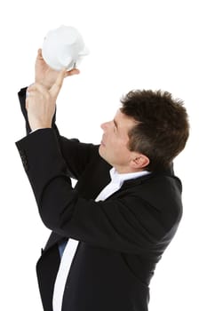 Attractive middle-aged man fishing money out of a piggy bank. All on white background.