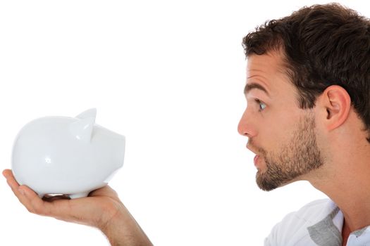 Young guy yells at his piggy bank. All on white background.