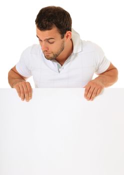 Curious guy standing behind white wall. All on white background.