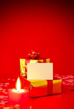 Two presents and blank card against red background