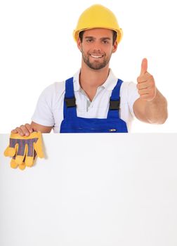 Construction worker making thumbs up while standing behind white wall. All on white background.