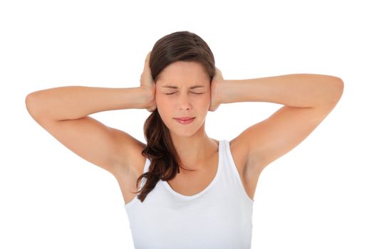 Attractive young woman keeping her ears shut. All on white background.