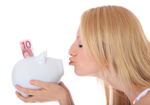 Attractive young woman kissing her piggy bank. All on white background.