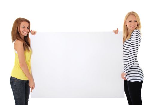 Two young women holding blank white sign with plenty copy space. All on white background.