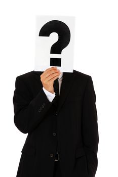 Businessman holding question mark in front of his head. All on white background.