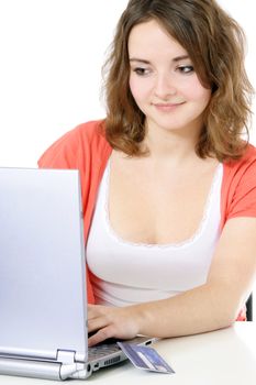 Attractive teenage girl using notebook computer. All on white background.