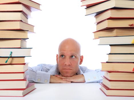 Attractive middle age man between two piles of books. All on white background.