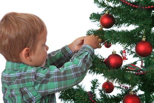 Cute caucasian boy decorating the christmas tree. All on white background.