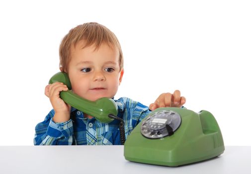 Cute caucasian boy using telephone. All on white background.