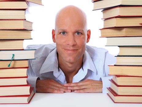 Attractive middle age man between two piles of books. All on white background.