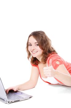 Attractive teenage girl lying on the floor, using notebook computer. All on white background.