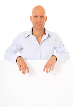 Attractive young man standing behind white wall. All on white background.