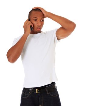 Attractive black man gets shocking news during phone call. All on white background.