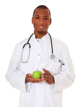 Attractive black doctor holding green apple. All on white background.