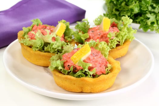 Corn cakes with salmon salad on a white background