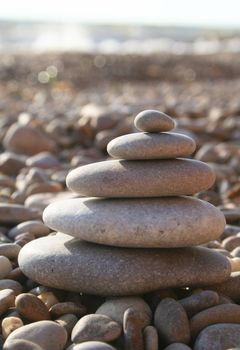Pyramid of water rounded stones on the sea beach