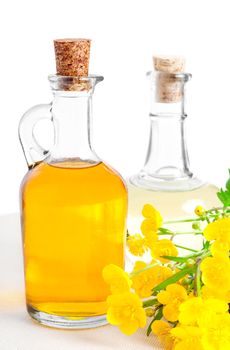 bottles of oil with buttercup, on a white background 