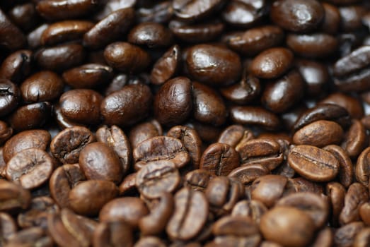 Decaffinated and caffinated coffee beans piled next to each other.