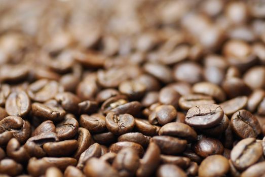 Pile of decaffinated coffee beans, short DOF focus on foreground.