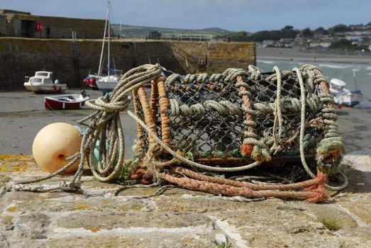 Lobster pot sat on a harbour wall in Cornwall, Uk.
