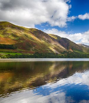Mountains reflect into Buttermere calm lake in English Lake District