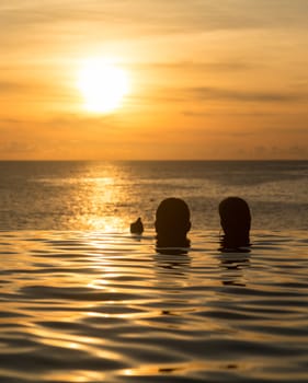 Edge of infinity swimming pool overlooking ocean at sunset