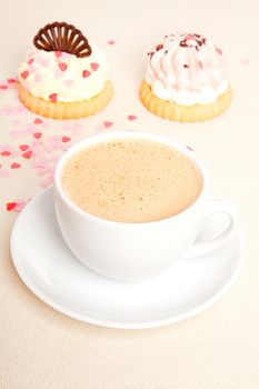 cup coffee with cake on tablecloth