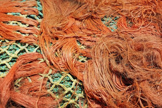 Multi-coloured fishing net in a tangle.
