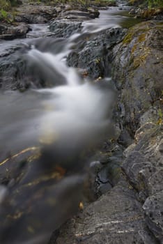 White water and rocks of small, fast moving stream. Cornwall, UK.