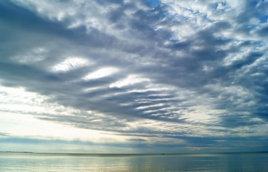 View fluffy clouds at sunset above the sea