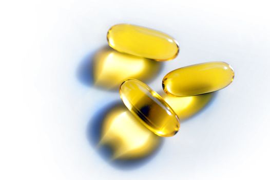 Pills or capsules in transparent yellow on white