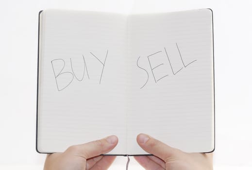 Buy/Sell choices on notepad, white background.