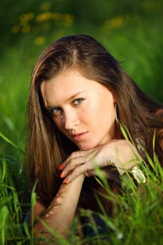 brunette lays on green grass