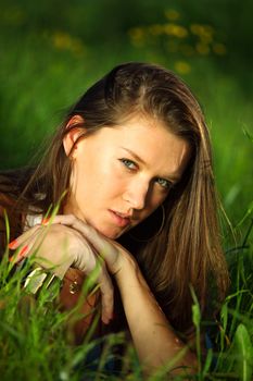 brunette lays on green grass