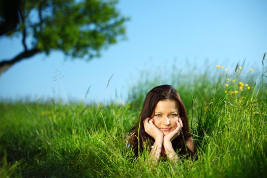 brunette lays under the tree 