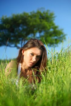 brunette lays under the tree 