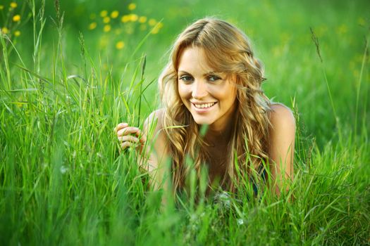 blonde lays on green grass