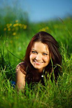 brunette lays on green grass