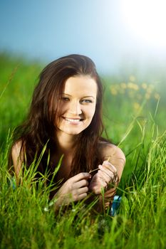 brunette lays on green grass