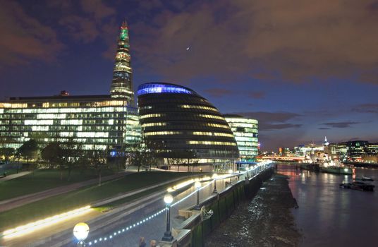 City skyline and River Thames iluminated by lights, including the Shard building and Mayors City Hall