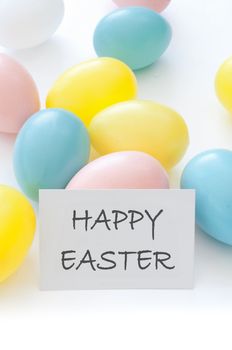 Pastel coloured easter eggs with a happy easter greeting card 