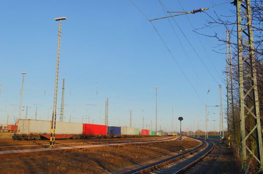 A freight yard under a beautiful blue sky.