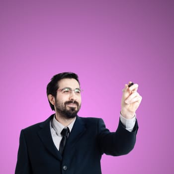 business man writing on imaginary screen on pink background