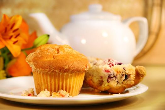 Breakfast with cranberry muffins, teapot and orange juice on bamboo mat