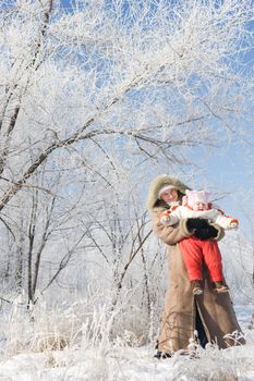 mother plays with her child in a beautiful winter forest
