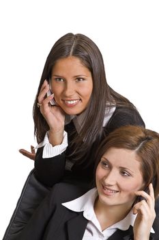 Portrait of two young businesswomen using mobile phones.