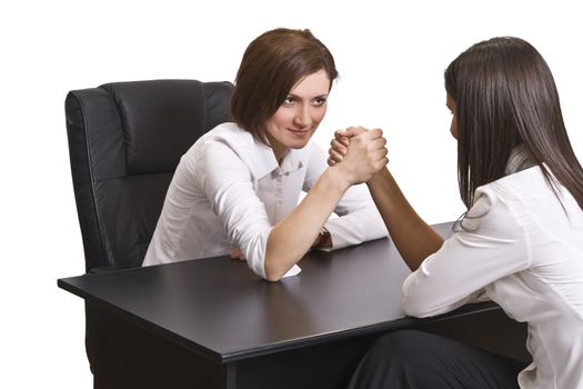 Businesswomen arm wrestling against a white background.