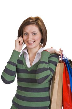 Portrait of a young woman with shopping bags using a mobile phone.