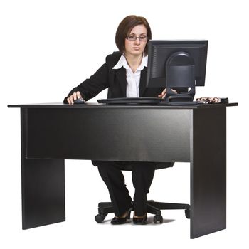 Businesswoman working on a computer at her office desk isolated against a white background.