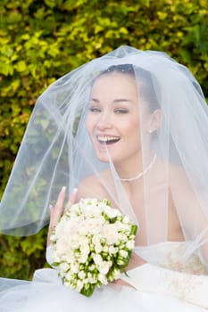 bride with a bouquet of flowers laughs